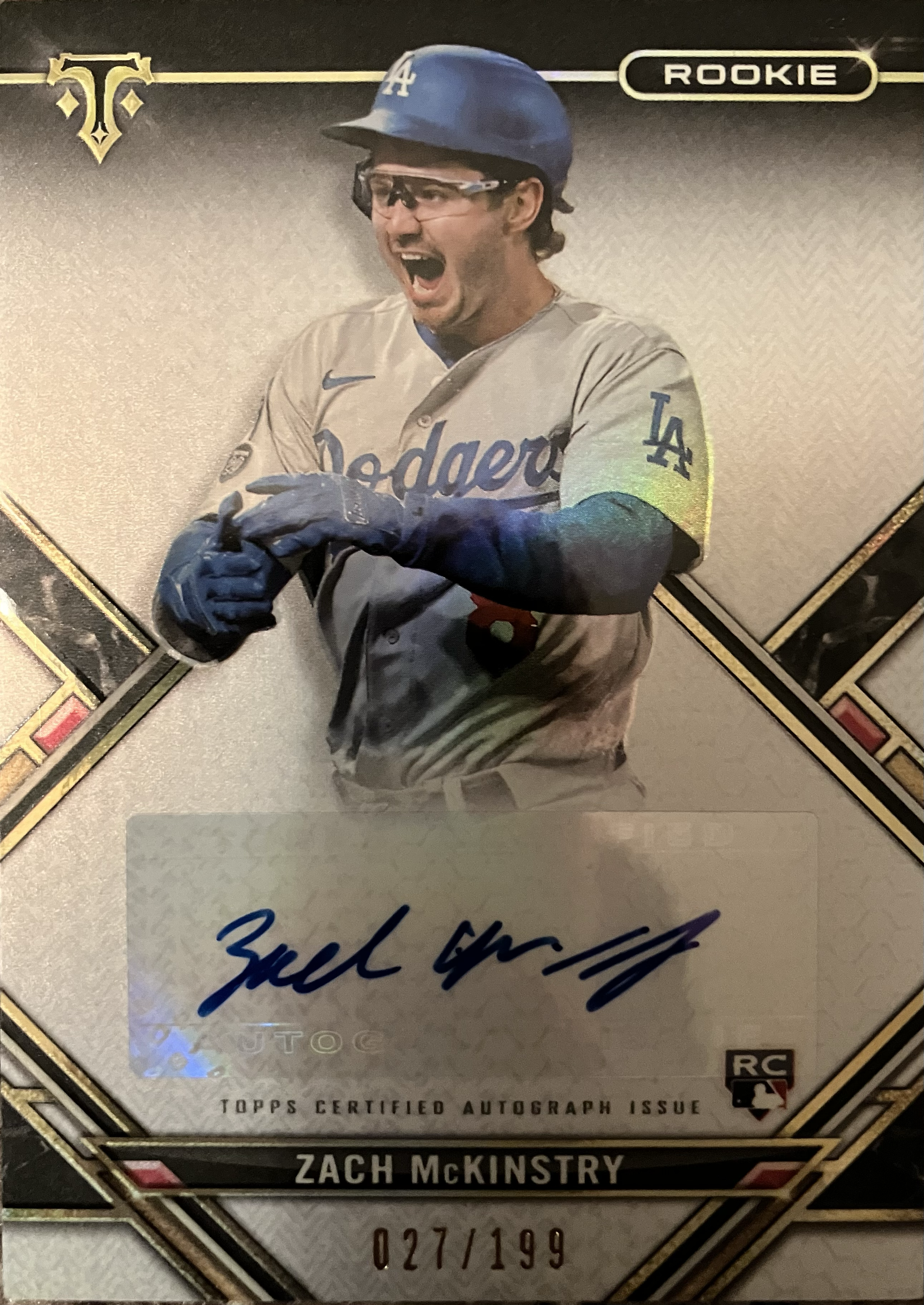 A baseball player in the middle of smiling and clapping.