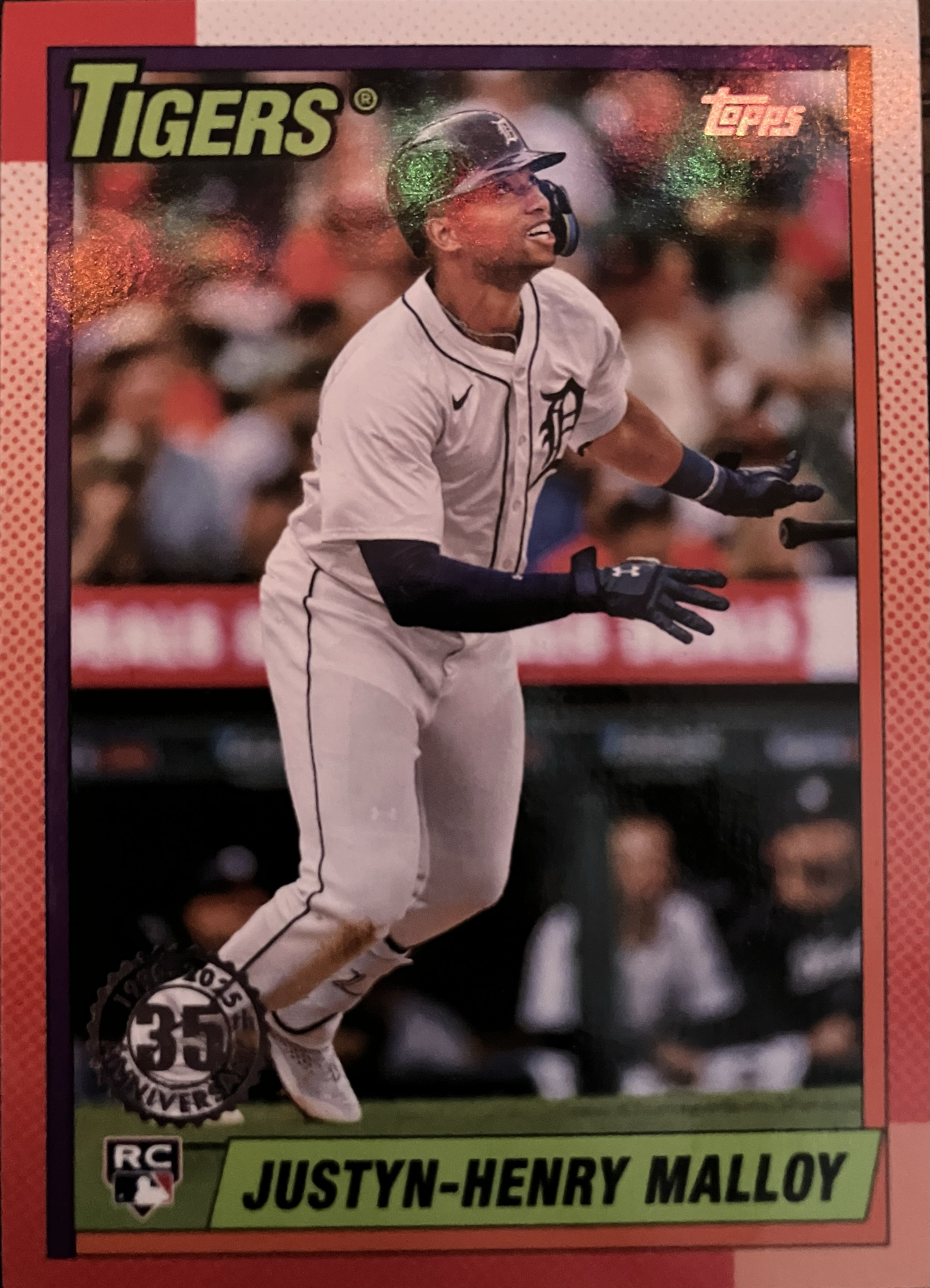A baseball player stares into the outfield and tosses the bat.