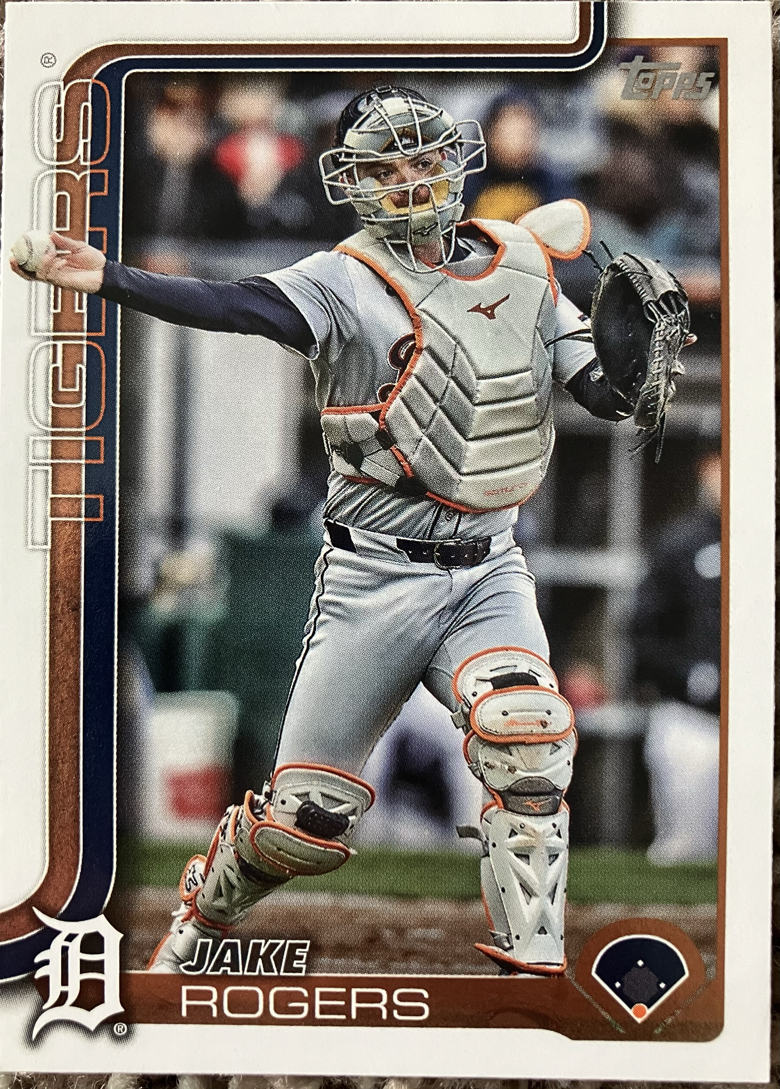 A baseball catcher throws a ball in full uniform.