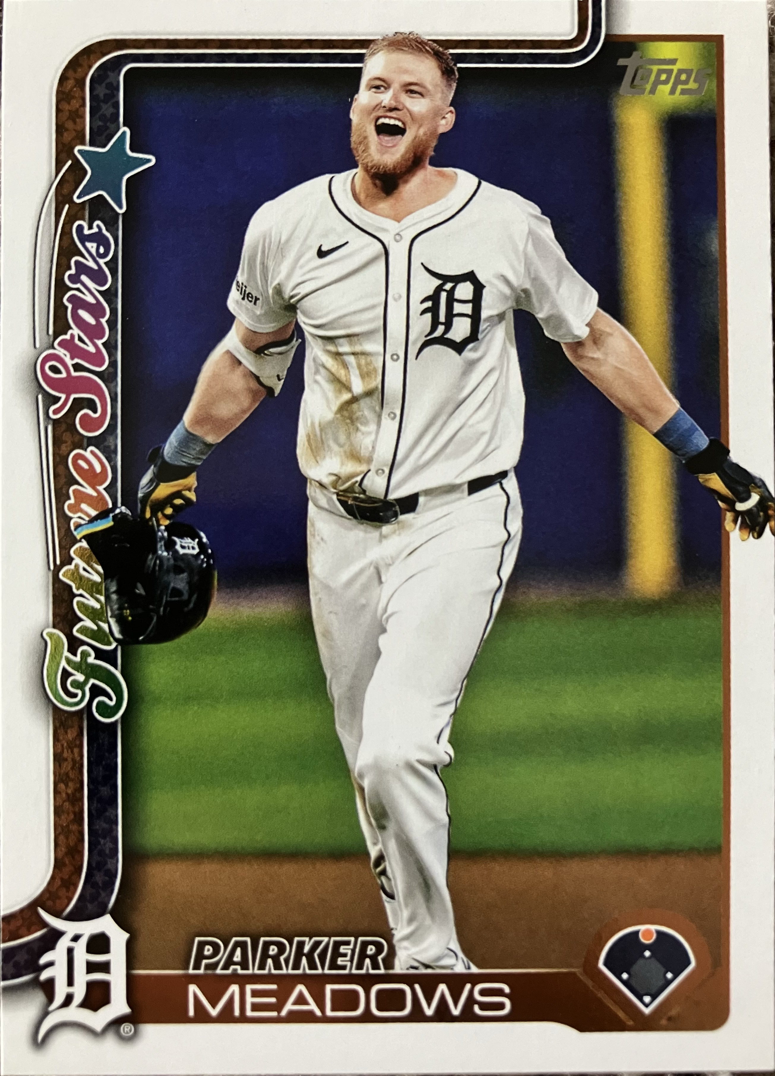 A player on the infield dirt holding his helmet in his hand in mid celebration.